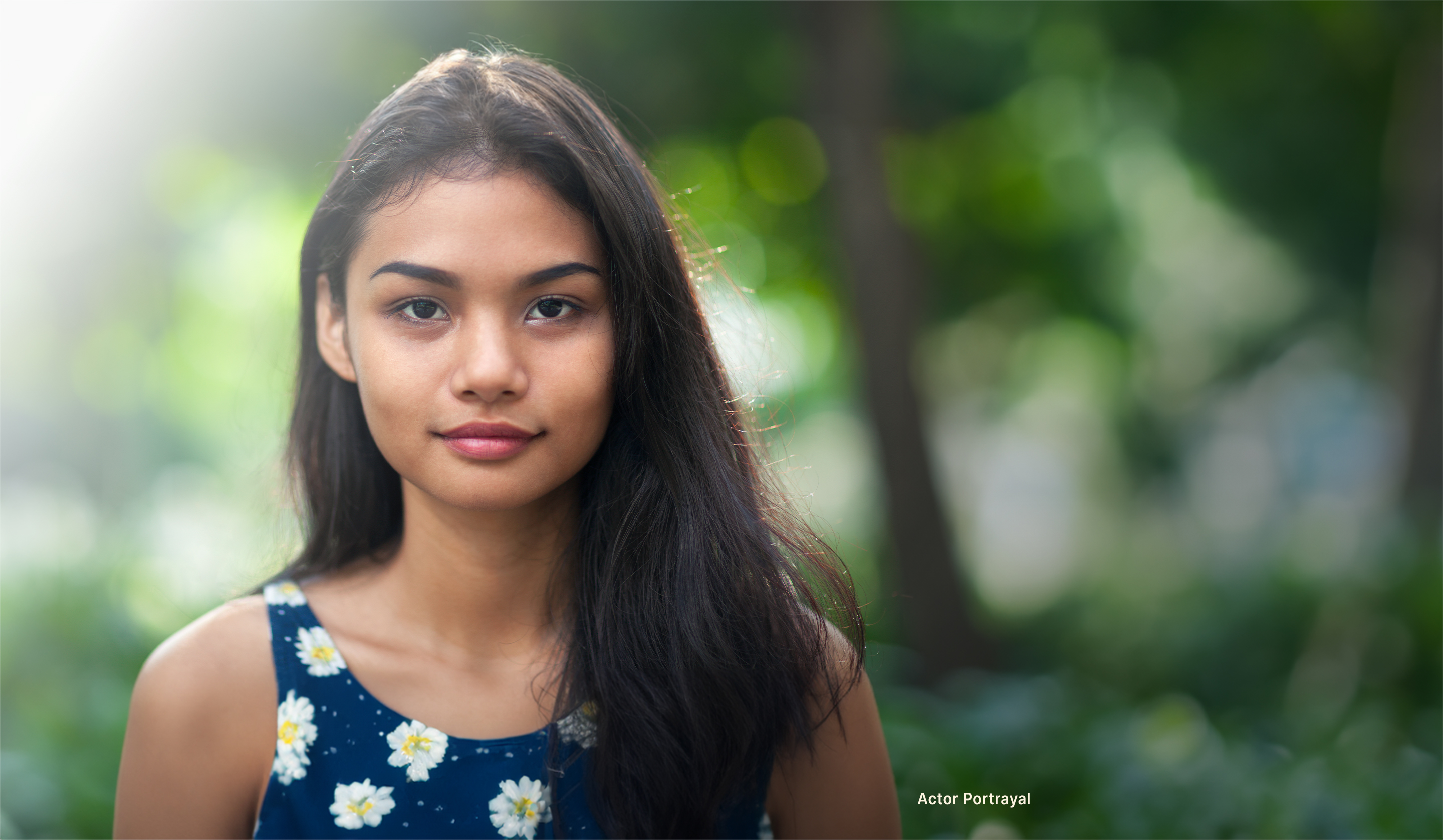 Actor Portrayal; A young Southeast Asian adult woman, in a floral top, slightly smiling while contemplating cervical cancer and HPV infections in women.